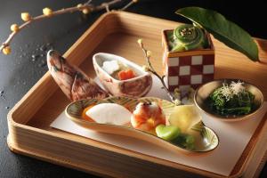 箱根强罗花坛传统日式旅馆的盘子上放着食物的木托盘