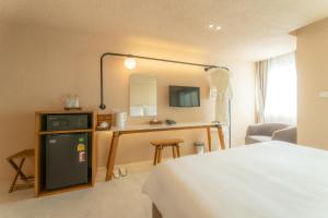 清迈Mai Hotel的配有一张床和一张书桌的酒店客房
