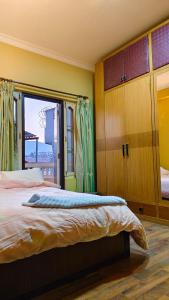 加德满都Bodhi Homestay的一间卧室设有一张大床和一个窗户。