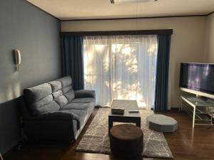 富士吉田市Guest House Fuji no Yado Akebono Building A - Vacation STAY 74316v的带沙发和电视的客厅