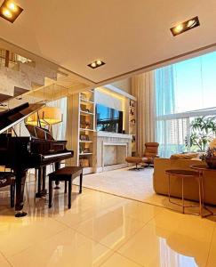 沙佩科Apto de Alto Luxo Duplex - Centro (área nobre)的客厅配有钢琴和壁炉