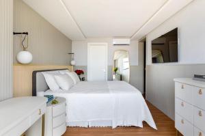 沙佩科Apto de Alto Luxo Duplex - Centro (área nobre)的卧室配有白色的床和镜子