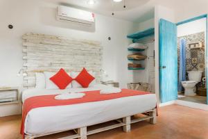 图卢姆Casa Toloc Tulum的一间卧室配有一张带红色枕头的大床