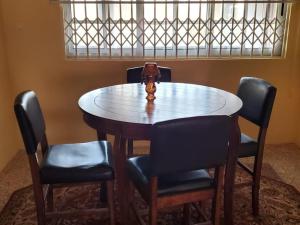 塔科拉迪Casa Consuelo Guest House的桌子,椅子和上面的花瓶