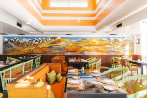 JomsomShinta Mani Mustang - A Bensely Collection的用餐室配有桌椅和壁画