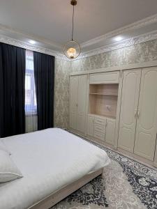 撒马尔罕Квартира Самарканд的卧室配有一张白色大床和吊灯。