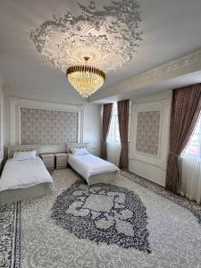 撒马尔罕Квартира Самарканд的一间卧室配有两张床和吊灯。