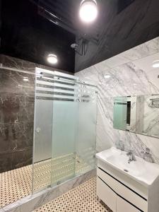 撒马尔罕Квартира Самарканд的一间带玻璃淋浴和水槽的浴室