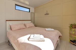 旺阿雷Valley View - Whangarei Tiny Home的一间卧室配有一张床,上面有两条毛巾