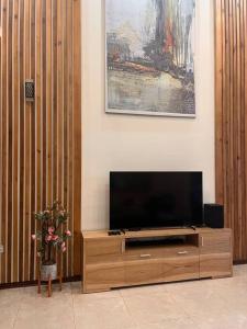 Plei Brel (2)Căn nhà của sự ngọt ngào!的木质娱乐中心设有带平面电视的客厅。