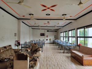 Pura RaghunāthHotel Dawat的宴会厅配有桌椅和窗户