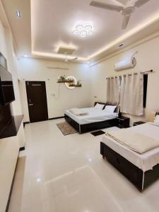 乌贾因DivineStay - Full Villa by AP Villas的一间卧室配有两张床和电视。