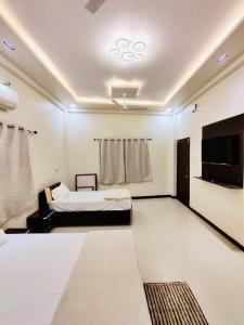 乌贾因DivineStay - Full Villa by AP Villas的一间卧室配有一张床和一台平面电视