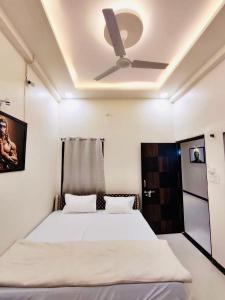 乌贾因DivineStay - Full Villa by AP Villas的一间卧室配有一张带吊扇的床