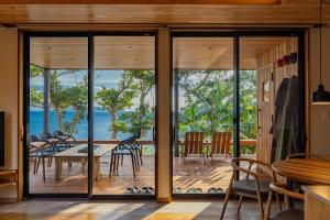 下田ガーデンヴィラ白浜　KOTI的一间设有玻璃门和桌椅的用餐室