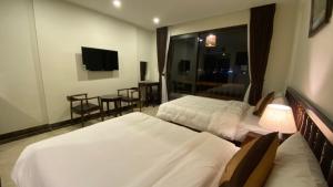 同文Dongvan Ville Du H'Mong Hotel的酒店客房设有两张床和电视。