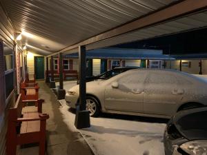 Howard CityTour Inn Motel的停放在地面雪地上的车库中的汽车