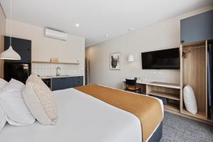 阿德莱德Comfort Inn Regal Park的酒店客房设有一张大床和一个厨房。