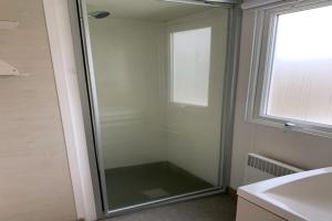 乌伊斯特勒昂Camping Riva Bella的带窗户的浴室内的玻璃淋浴间