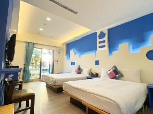 南湾黃金海岸36海景旅店的酒店客房设有两张床和蓝色的墙壁。