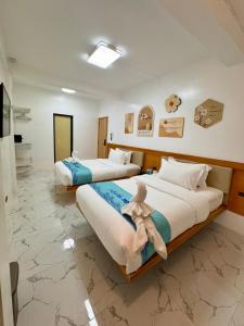 长滩岛LuckyTito Dmall Boracay的一间卧室配有两张带毛巾的床