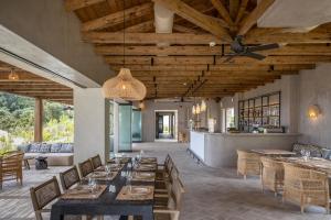斯巴达Eliamos Villas Hotel & Spa的餐厅设有木制天花板和桌椅