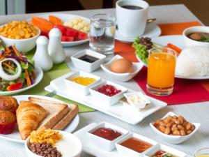 曼谷宜必思曼谷沙吞酒店 的一张餐桌,里面装满了早餐食品和饮料
