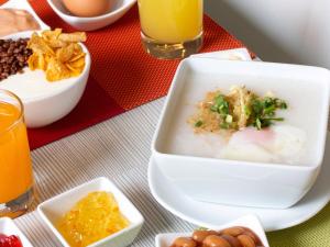 芭东海滩Ibis Phuket Patong的饭桌上放一碗汤和一盘食物