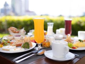 曼谷宜必思曼谷河畔酒店的餐桌,带食物盘和橙汁杯