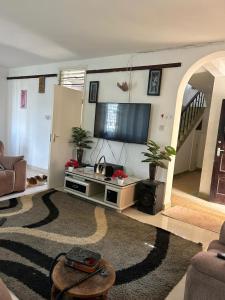 蒙巴萨Mopearlz 4bedroom villa Nyali的客厅配有平面电视和沙发。