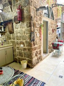 阿卡Hebi house的一间设有石墙的房间和一张桌子,上面有食物