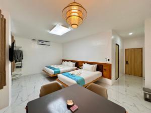 长滩岛LuckyTito Dmall Boracay的酒店客房设有两张床和一张桌子。