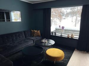 RjukanRjukan Sentrum Apartments NO 1的客厅配有沙发、桌子和窗户
