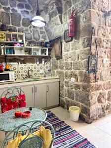 阿卡Hebi house的厨房配有桌子和石墙