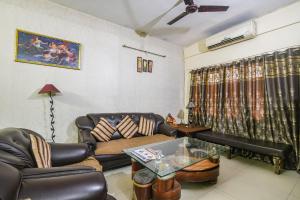 巴特那FabHotel Maadhavam Residence的客厅配有沙发和桌子