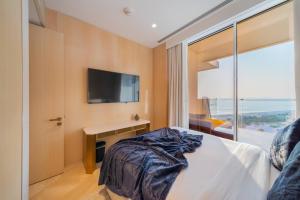 迪拜FIVE Palm Resort - Luxury 2BR - Sea View的一间卧室配有一张床,墙上配有电视