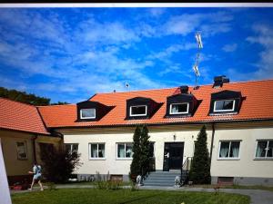 LjugarnEkängens Pensionat Garde的一个人走过一座橙色屋顶的房子