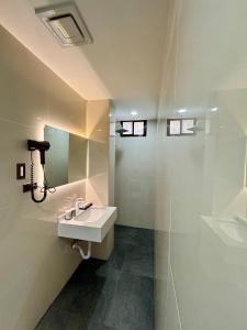 长滩岛LuckyTito Dmall Boracay的白色的浴室设有水槽和淋浴。