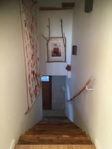 Le clos du chêne - Chambres dans maison Bressane的走廊上设有楼梯,墙上挂着一幅画