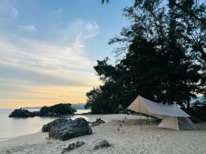 峇六拜Cosy HomeStay at Penang Island -Beach and Village的沙滩上靠近水面的白色帐篷