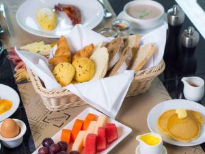 曼谷诺富特曼谷素坤逸4酒店 的一张桌子,上面有两篮面包、水果和鸡蛋