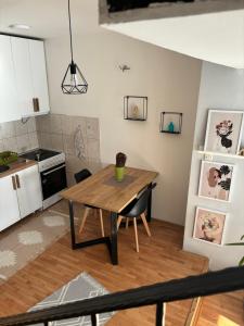 斯科普里Mia’s duplex apartment的厨房以及带木桌的用餐室。