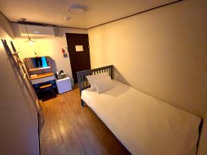 首尔Hostel Korea - Ikseon的一间带床和电视的小卧室