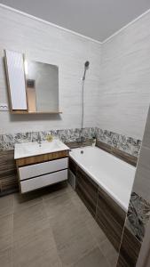 科克舍套ЖК Ауэзова1的带浴缸、水槽和镜子的浴室