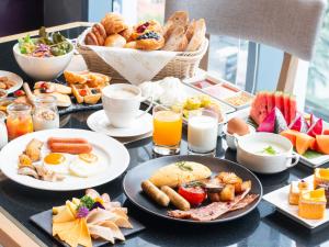 曼谷曼谷素坤逸 24 号美居酒店的早餐桌,包括早餐食品和饮料