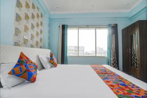 巴特那FabHotel Raj Niwas的卧室配有一张大白色床和窗户