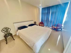 功孟海滩Chez Wanida - apartment Krabi的卧室配有一张白色大床和两把椅子