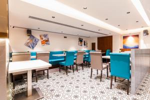 孟买Treebo Tryst Heritage Grand - Thane的一间配备有桌子和蓝色椅子的用餐室