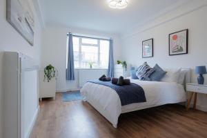 伦敦Lovely 2-bed Highbury Home的白色的卧室设有床和窗户