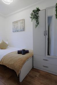 伦敦Lovely 2-bed Highbury Home的一间卧室配有床和白色橱柜